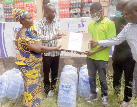 Isaac Kwadjo Buaben (2nd from left),  the Nsawam-Adoagyiri MCE, being assisted by Christiana Tamakloe, to present a laptop computer to Mr Joseph Mensah (3rd from right), a visually impaired student at the University of Education, Winneba. Picture: SAMUEL KYEI-BOATENG