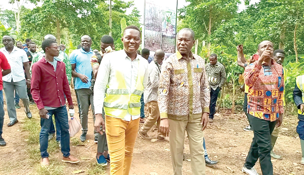 Frank Amamo Antwi (left), the District Cocoa Officer, Sefwi Bekwai, leading Joseph Boahene-Aidoo and his entourage through the rehabilitated farm