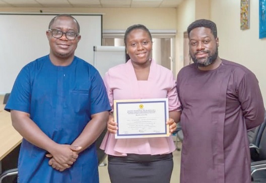   Ernest Apenteng (left), General Manager,  Clare Agyekum Mensah (middle), General Administration Manager, Cornelis Rouloph-Otoo (right), Head of Legal and Corporate Affairs, displaying the  certificate from BoG