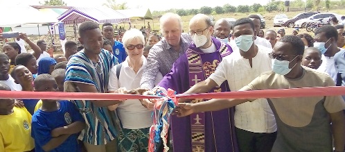 Rev. Fr.  Bernard Heistakamp (3rd from right), Aktion-Lichtblicke-E. V. Ghana, being assisted by Richmond Tetteh Agamlorh (left), the acting Director of Rays of Hope Centre and other dignitaries to cut the tape to commission the facilities