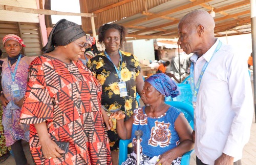 Cecilia Abena Dapaah (left), Caretaker for the Ministry of Gender, Children and Social Protection, having a conversation with some beneficiaries during the LEAP benefit payment at Dakwadwom in Kumasi
