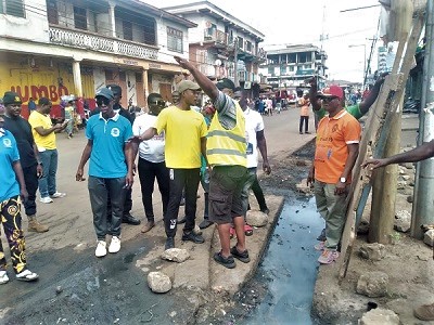 Samuel Pyne (hand raised), KMA MCE, with some staff at Pampaso where some gutters were desilted