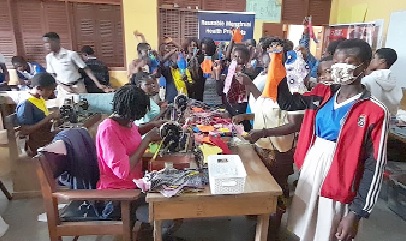 Some of the students displaying the sewn reusable menstrual pads while watching the tailors at work