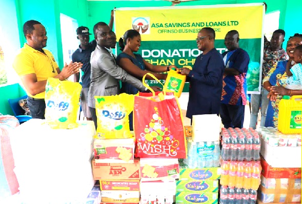 Joana Boaffour Adjei (3rd from left), Offinso Branch Manager of ASA Saving and Loans Limited, being assisted by Felix Ahiadome (2nd from left), to present the items to Nana Konadu (3rd from right), Founder, Ashan Children’s Home.