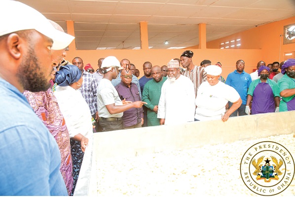 President Akufo-Addo (arrowed) being briefed  during a tour of the Global Almas Processing Ltd, a yam and cassava processing factory located in Bimbilla in the Northern Region