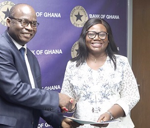 Dr Ernest Addison, Governor of the BoG, exchanging documents with COP Maame Tiwaa Addo-Danquah, Director of EOCO