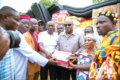 Former President John Mahama presenting the items to the Appiatse Disaster Relief Committee