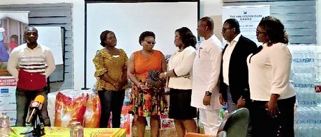 COP Maame Tiwaa Addo-Danquah (middle) with other celebrants presenting the cash and items to Angela Dwamena-Aboagye (3rd from left), Executive Director of the Ark Foundation