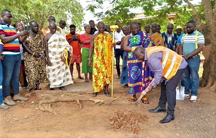 John Osei Frimpong (with pickaxe), Member of Parliament for New Abirem, digging the ground for the commencement of work on the 64-lockable stores at New Abirem. Looking on are the Abiremhene, Obrempong Akwasi Amo Tweretwea (middle) and other officials of the assembly.