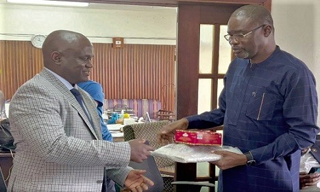 Clifford A. Braimah (right), Managing Director of GWCL, presenting a laptop and Ghanaian chocolates to Maada Kpenge (left), Managing Director of GVWC