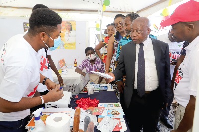 Kwaku Agyeman-Manu (right), Minister of Health, inspecting an item at an exhibition at the 2022 World Aids Day in Accra. With him are Dr Leticia Adelaide Appiah (3rd from right),  Executive Director of the National Population Council, and others. Picture: GABRIEL AHIABOR