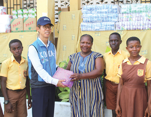 Moo Heon Kong (2nd from left), Country Director, KOICA-Ghana, presenting some items to Christina Kailebi Adom Bortey (middle), Headmistress of Dar-Es-Salaam Primary School. Picture: ESTHER ADJORKOR ADJEI