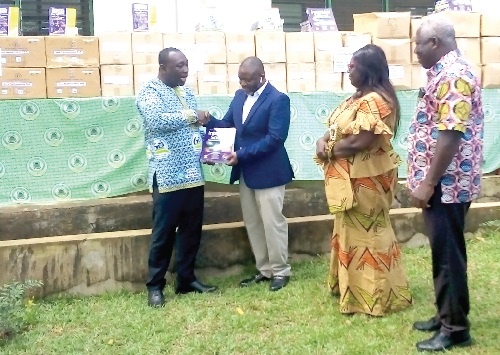 Samuel Fletcher (left), Community Relations Manager of VRA, handing over the books to  Prosper Agbenyo, Asuogyaman District Coordinating Director