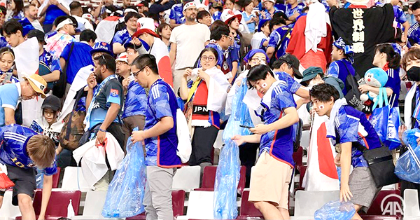 Some Japanese football fans cleaning the stadium after a match at the 2022 FIFA World Cup
