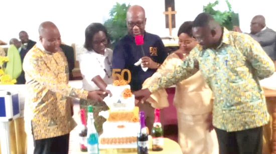 Rev. Dr Hilliard K. Dela Dogbe (middle) being assisted by leading members of the planning committee to cut the 50th anniversary cake 