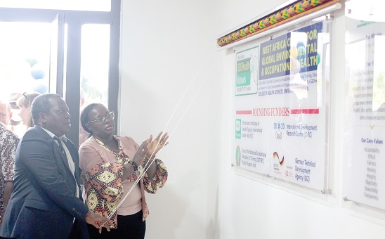 Prof. Nana Aba Appiah Amfo (right), Vice-Chancellor, University of Ghana, applauding as Prof. Julius Fobil (left), Provost, College of Health Sciences, UG, unveils a plaque to inaugurate the research facility. Picture: MAXWELL OCLOO