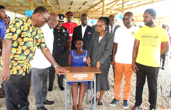  Rev. Dr Betty Baidoo (3rd from right), Assistant Headmistress, St John Grammar School; Supt Olivia Turkson (3rd from left), President of JOSA 1991, and Joseph Darko (2nd from left), Mathematics teacher of the school, watching a student try one of the desks