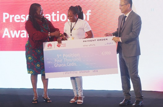 Ursula Owusu-Ekuful (left), Minister of Communications and Digitalisation, and Tommy Liang (right), Managing Director of Huawei Ghana, presenting a dummy cheque to Gloria Ankomah, winner of the 2022  Huawei Seeds for Future programme. Picture: ESTHER ADJORKOR ADJEI