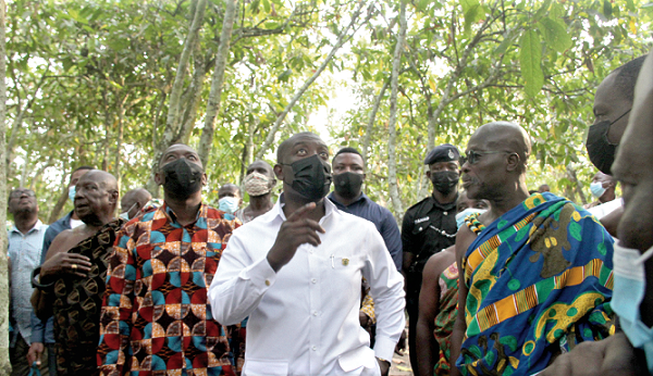 Mr Kojo Oppong Nkrumah (middle), Minister of Information,  touring the late Tettteh Quarshie’s first cocoa farm at Akuapem Mampong. He was led by Osaberima Kwame Ottu Darte III, Chief of Akuapem Mampong (right). With them is Mr Herbert Krapa (2nd from left), Deputy Minister, Trade and Industry. Picture: BENEDICT OBUOBI