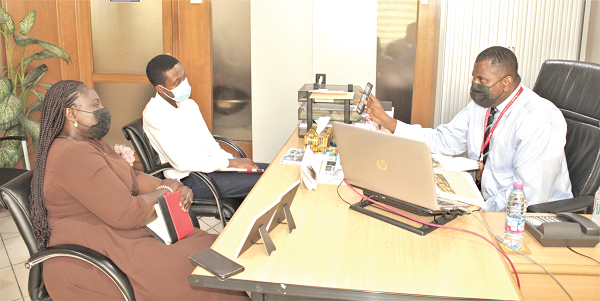 Mr Franklin Sowa (right), Director, Marketing and Sales, Graphic Communications Group Limited, showing an application to Mr Ewusi Safo Nana Yaw (2nd from left), Administrative Assistant, CANCHAM, and Mrs Edwina Atta-Sonno, Executive Secretary, CANCHAM, during the interaction. Picture: ERNEST KODZI