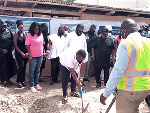 Nana Owiredu Wadie I (with pick-axe), Nkosuohene of Kwahu-Nkwatia, digging the ground to start the construction work. Looking on are the staff of the Kabaka Foundation as well as the staff of the hospital