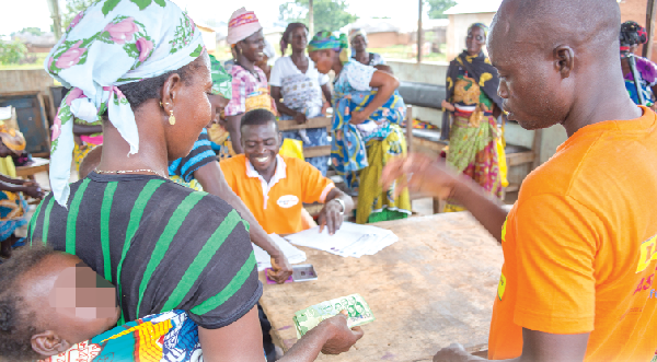 A LEAP beneficiary (left) receiving her cash grant