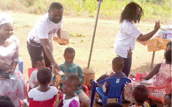 Some staff of Ghana Tourism Authority sharing chocolates to children at the Apostolic Church, Koforidua