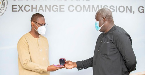 Mr James Bruce (right), Executive Director of Access Bank, presenting the gold coin to Rev. Daniel Ogbarmey Tetteh