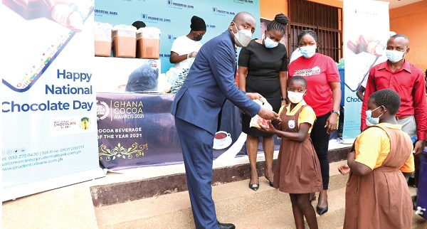 Mr Ebow Quayson presenting a bar of chocolate to one of the pupils
