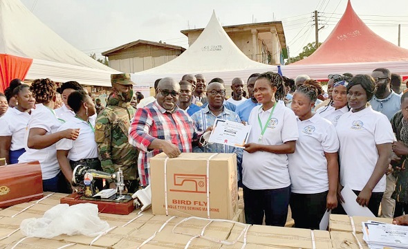 Mr Kofi Amankwah-Manu, Deputy Minister of Defence, presenting a sponsorship package to one of the beneficiaries