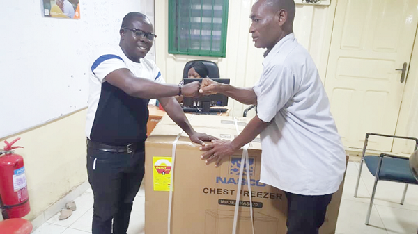 Mr Abdul Rahman Abdullah, Ayawaso East Municipal Engineer, presenting a fridge to one of the beneficiaries of the Disability Fund