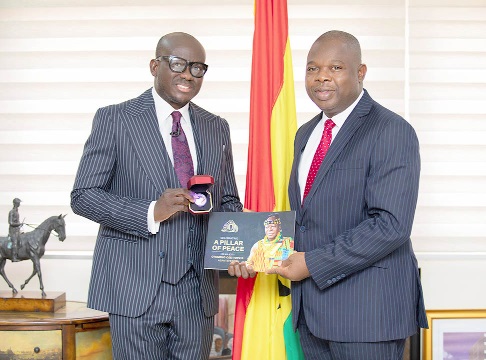 Mr Ade Ologun, Chief Operating Officer of Access Bank (left), presenting the coin to Mr Godfred Yeboah Dame