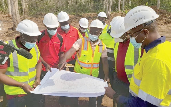 Isaac Mabee (middle), Project Geologist of Rocksure, explaining the Exploration Drilling Plan to the GIADEC team that visited the site