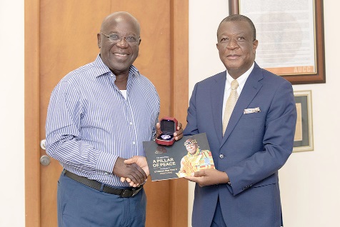 Mr Paul Asimenu (right) presenting the gold coin to Mr Sam Jonah