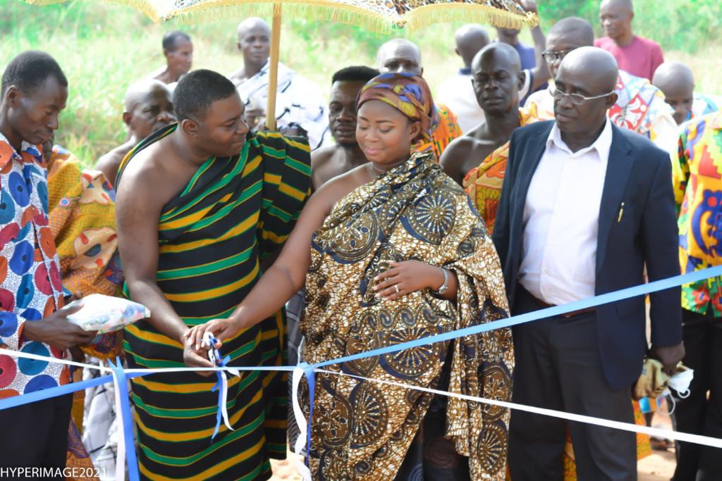 The Nkosuohemaa (middle) being assisted to cut the sod for the project.