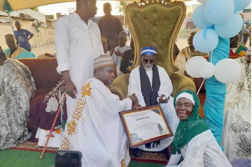 An executive member of the Haddin Kai Hausa da Hausawan Duniya Foundation presenting a citation to Sheikh Osmanu Nuhu Sharubutu, National Chief Imam