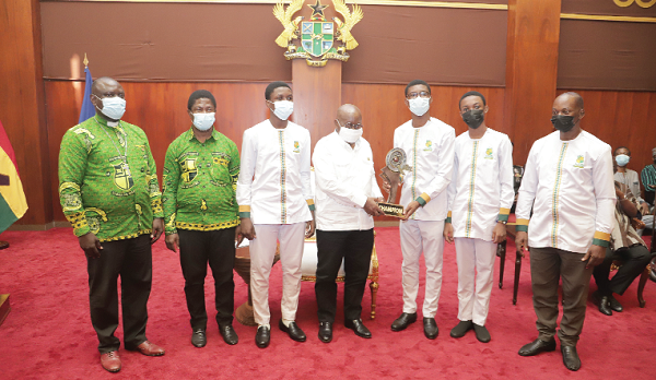  President Akufo-Addo (middle) receiving the trophy from representatives of Prempeh College who won the 2021 National Science and Maths Quiz. Picture: SAMUEL TEI ADANO