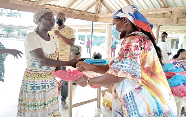Madam Charlotte Adwoa Antwi presenting a package to a constituent