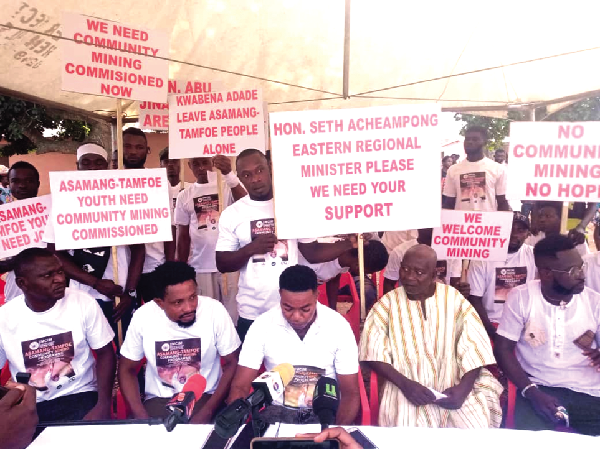 •Mr Kwadwo Nti (seated 2nd from right), the Organiser of the youth group, addressing media practitioners at Asamang-Tamfoe on Tuesday while some members hold placards with different inscriptions.