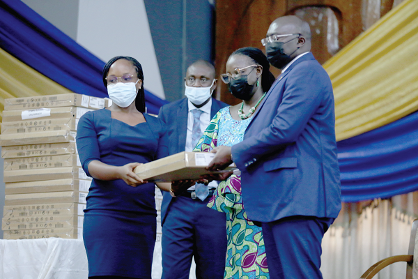 Vice-President Alhaji Mahamudu Bawumia (right) and Prof. Nana Aba Amfo (2nd from right), Vice-Chancellor, University of Ghana, presenting a laptop to one of the beneficiaries. 