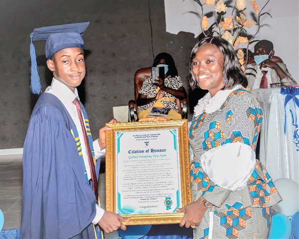 Ms Doris Aku, headmistress, Accra College of Education,­ presenting the overall best student award to Master Gabriel Frempong Yaw Ayim