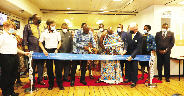 Mr Yohane Amarh Ashitey (4th from left), Chief Executive of Tema, being aided by Nii Adjetey Agbo II (2nd from right), Mankralo of the Tema Traditional Area, Mr Randy Grede (right), the Managing Director, Logos Hope, and Captain James Berry (2nd from left), the ship's captain, to cut the ribbon to open the book fair.  Looking on are other guests including Dr Lawrence Tetteh, Founder and President of the Worldwide Miracle Outreach. Pictures: EDMUND SMITH-ASANTE