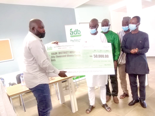 Alhaji Alhassan Yakubu Tali (2nd from left), Deputy MD of ADB, presenting the cheque to Habib Iddrisu, MP for Tolon, to be handed over to the hospital's management