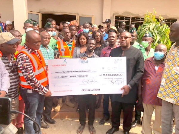 Dr Ben Asante (3rd from right), Chief Executive of Ghana Gas, presenting a dummy cheque for the amount  to Dr Isaac Dasmani, Municipal Chief Executive for Prestea Huni-Valley municipality, while some officials of Ghana Gas and the municipal assembly look on 