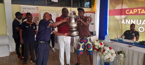   Mr Appiah (far left) being assisted by Mr Mike Aggrey, the GGA president, to present the winner’s trophy to James Akwaboah (right).