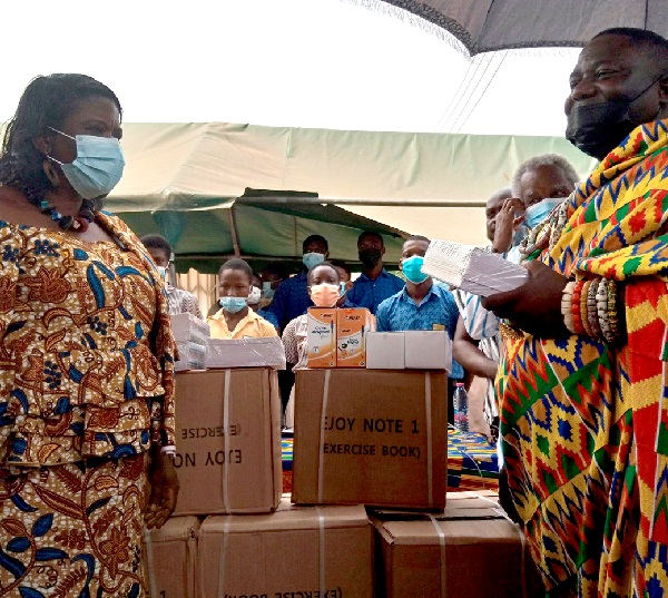  Nii Tettey Ofro Osro I (right), Chief of La Leshie, presenting the learning materials to Madam Habiba Kotomah, La Dadekotopon Municipal Director of Education
