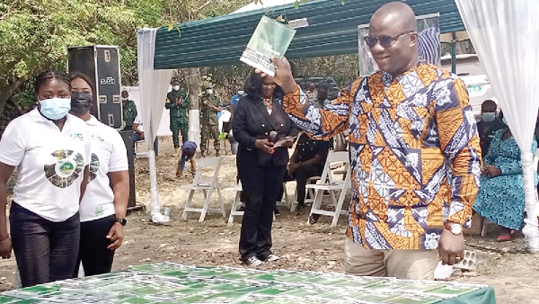  Mr Samuel A. Jinapor, Minister of Lands and Natural Resources, with the book raised at the launch at the Shai Hills Resource Reserve in the Greater Accra Region