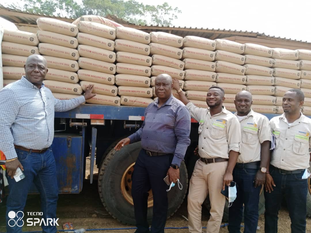 Mr Eric Darko of Asanko (left) showing the MCE samples of the bags of cement donated.