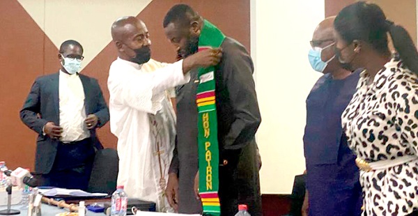 Rev. Fr Cyril Nii Yeboah Otoo, the officiating minister, adorning Mr Bartlett-Vanderpuye with a sache after the inauguration 