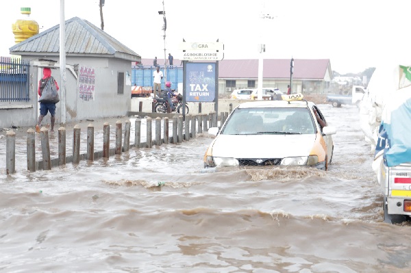 A taxi making its way through the flooded road at Agbogbloshie.